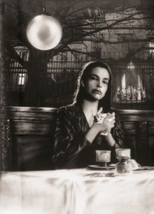 Photographie d'une jeune femme asisie à une table