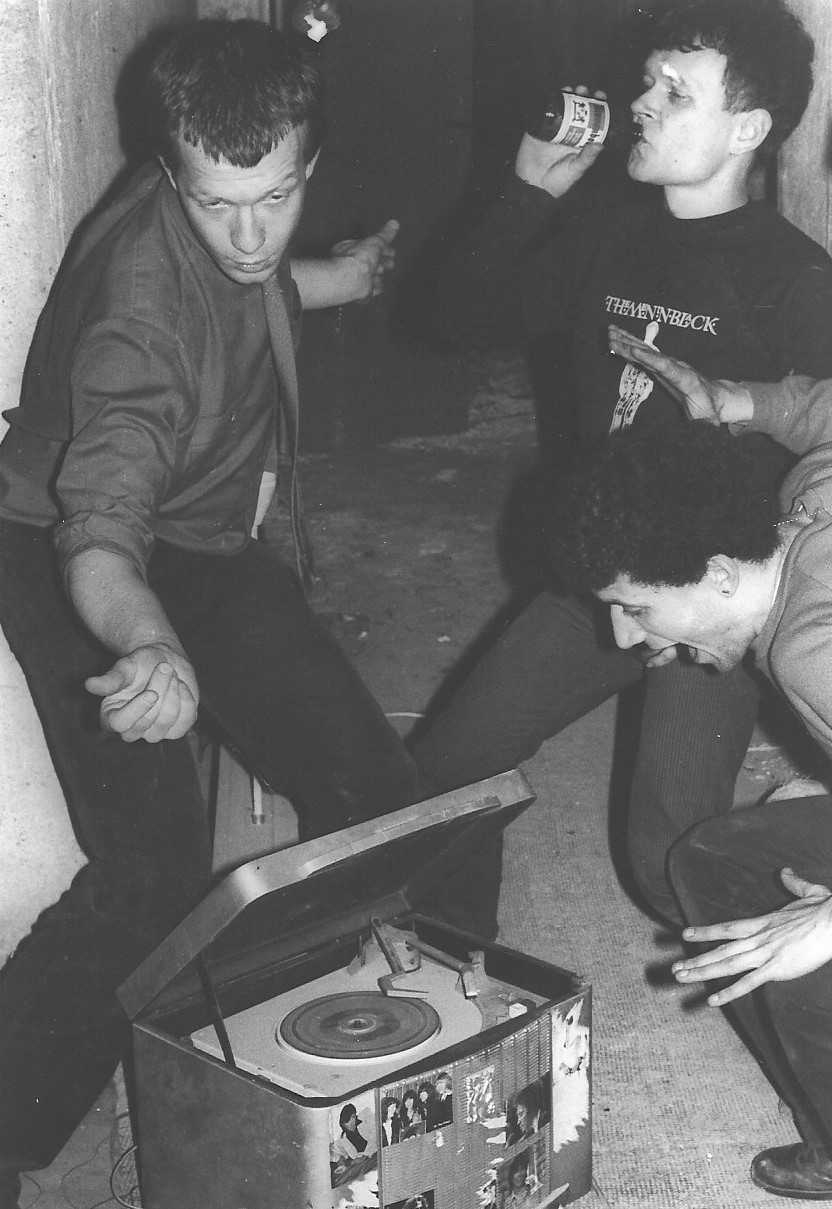 Photographie noir blanc d'un groupe de jeunes hommes avec un tourne-disque